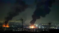 Asap tebal membumbung di dekat Menara Azadi setelah serangan udara di sekitar Bandara Internasional Mehrabad, Teheran, Iran, 7 Maret 2026.