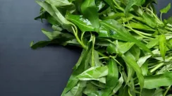 Tumpukan sayuran kangkung segar di pasar, simbol bahan pangan populer yang jarang disajikan dalam menu rumah sakit karena alasan medis.