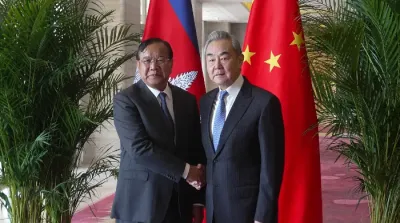Menlu China Wang Yi dan Menlu Kamboja Prak Sokhonn berjabat tangan usai pertemuan di Yuxi, Provinsi Yunnan, China.