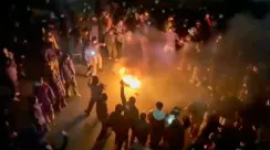 Pengunjuk rasa mengelilingi api di jalanan Teheran pada malam hari saat protes anti-pemerintah meningkat.