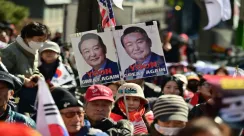 Massa pendukung membawa poster dan spanduk di luar Pengadilan Distrik Pusat Seoul, menyerukan pembebasan mantan Presiden Yoon Suk Yeol saat sidang vonis pemberontakan.